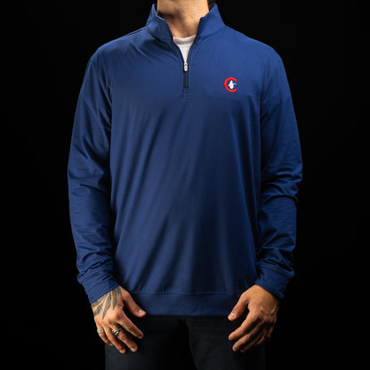 A man wearing a royal blue quarter-zip pullover jacket with a small red, white, and blue circular Chicago Cubs golf logo on the left chest, photographed against a solid black background.