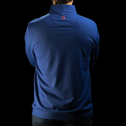 A man viewed from the back wearing a royal blue long-sleeve quarter-zip pullover with a small red shield logo on the upper back, set against a solid black background.