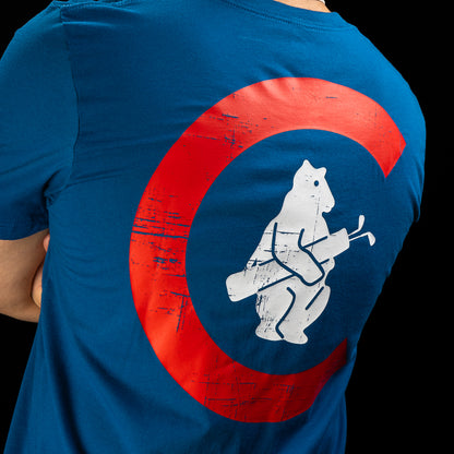 A close-up of a person wearing a blue T-shirt, showing the back of the shirt with a large distressed red circular graphic and a white bear playing golf inside the circle, against a black background.