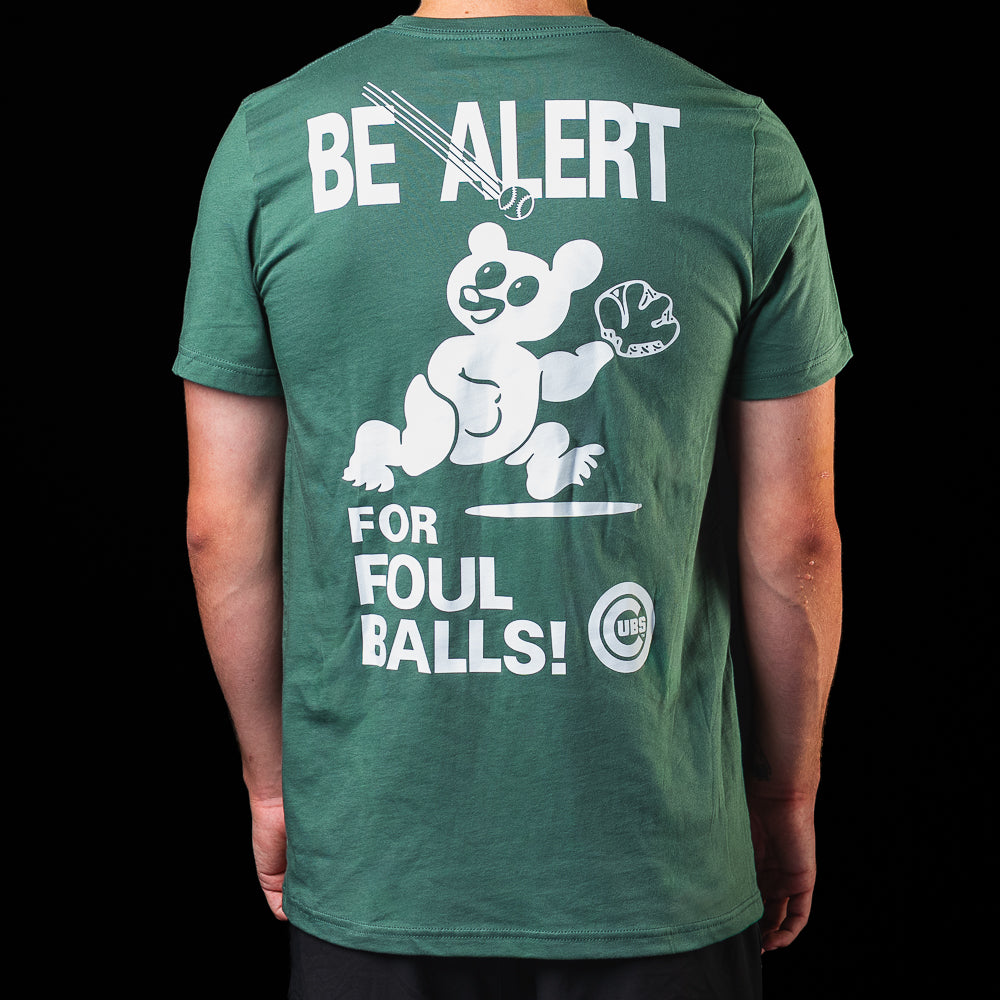 Back view of the green Chicago Cubs Be Alert For Foul Balls T-Shirt featuring a large foul ball warning graphic.