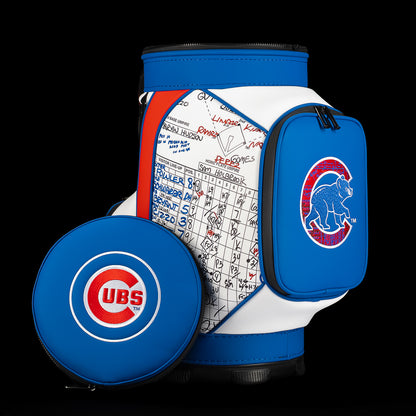 A Chicago Cubs golf bag cooler set against a solid black background, featuring a blue and white zippered main body with a white scorecard insert, a blue side pouch with the Cubs bear logo, and a separate round blue zippered case in front.