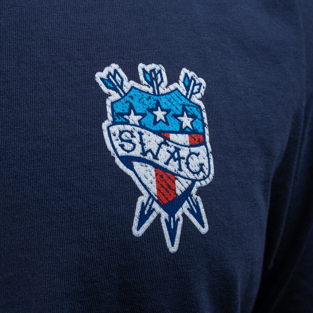 Person wearing a SWAG Golf navy blue short sleeve graphic t-shirt with a tattoo themed logo on the chest against a black background