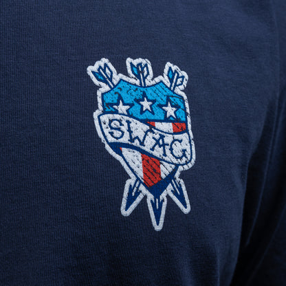 Person wearing a SWAG Golf navy blue short sleeve graphic t-shirt with a tattoo themed logo on the chest against a black background