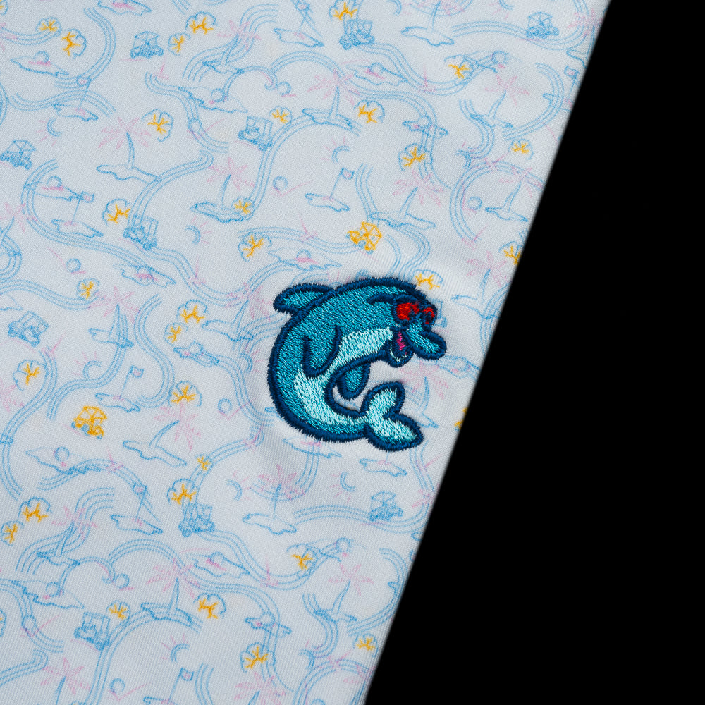 Light blue Peter Millar polo with a tropical golf course pattern and a blue flipper on the left chest.