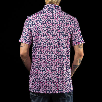 SWAG Golf x G/FORE navy and pink floral tech men's golf polo shirt with Miami Flipper logo over the left chest. 