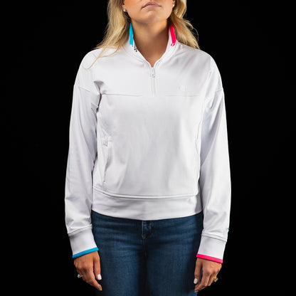 SWAG Golf x G/FORE women's long sleeve white quarter zip with blue and pink accents.