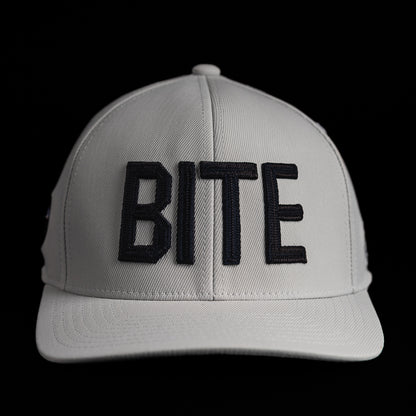 SWAG Golf x G/FORE white flexfit 110 snapback golf hat with BITE letters on the front.