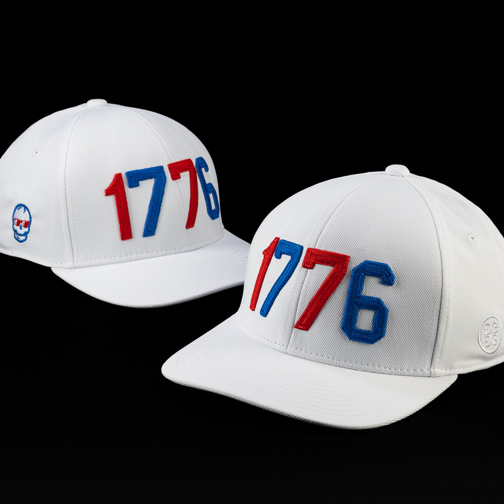 Front angled view of the 1776 hat featuring embroidered red, white, and blue 1776 lettering on a white structured cap with a curved brim.