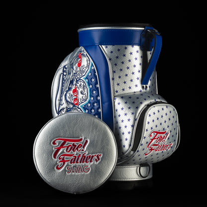 Fore! Fathers Den Caddy Cooler featuring patriotic red, white, and blue graphics with Founding Father illustrations, stars, and embroidered Fore! Fathers logo on the front pocket and lid.