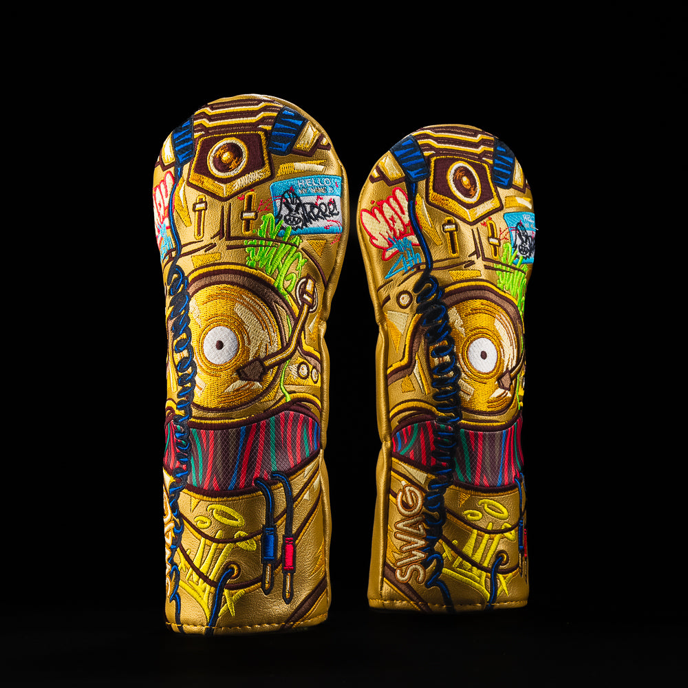 Gold robot themed SWAG Golf fairway headcover with colorful graffiti embroidery, blue wires, and a “Hello My Name Is” sticker on metallic gold.
