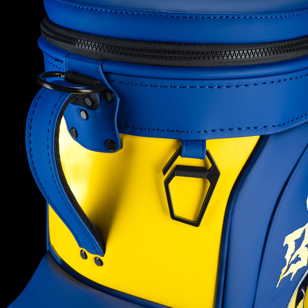 Michigan Wolverines Go Blue Den Caddy Cooler close-up featuring maize panel, blue zipper, pull tabs, and metal bottle opener