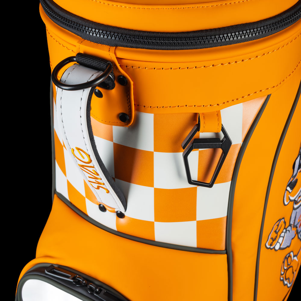 Close-up of Tennessee Volunteers Smokey Den Caddy Cooler featuring orange and white checkerboard print, zipper details, and metal bottle opener