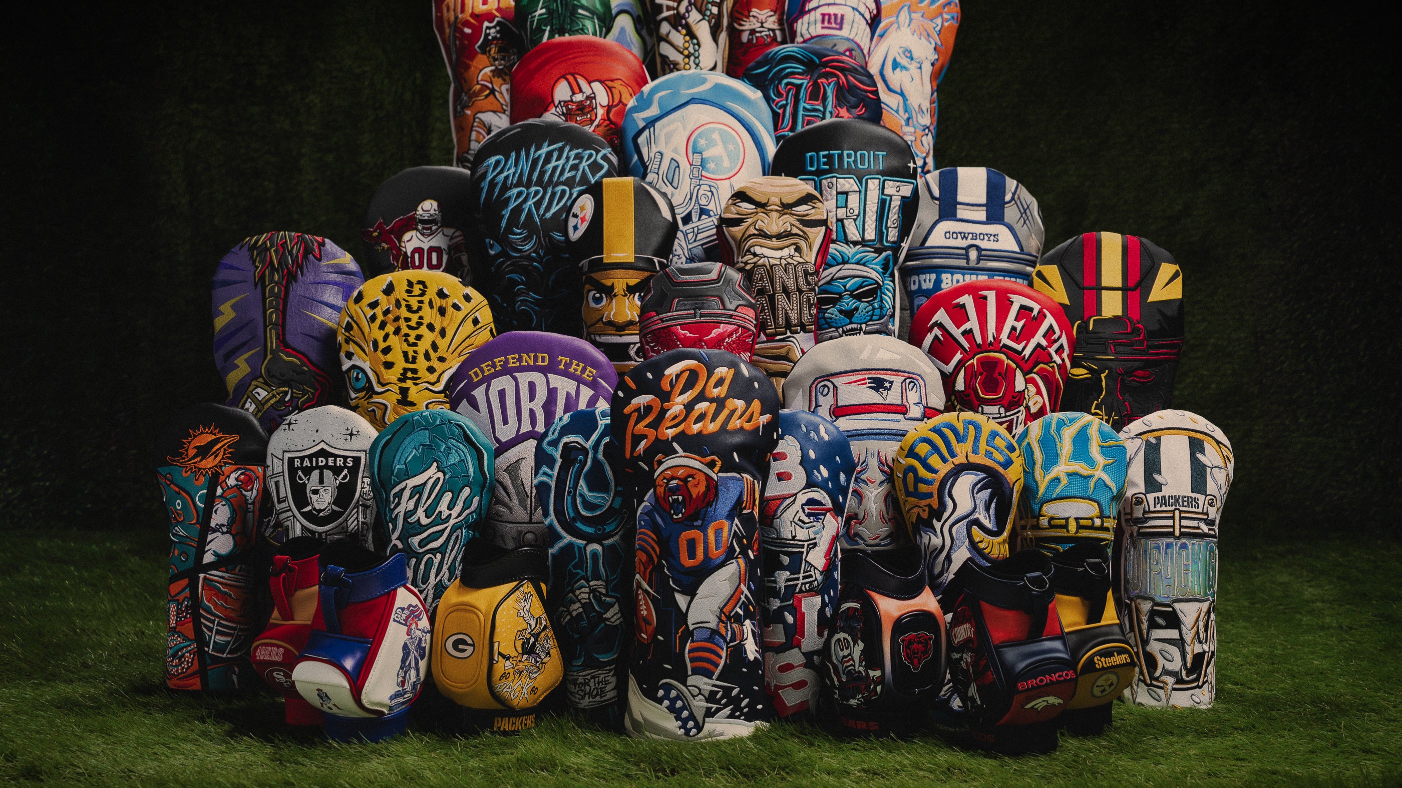 Group shot NFL x SWAG Golf headcover and desk caddy collection featuring all 32 officially licensed teams on green grass.