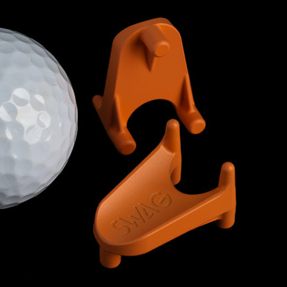 SWAG Golf orange mini kicking tee golf ball marker accessory made of stainless steel.