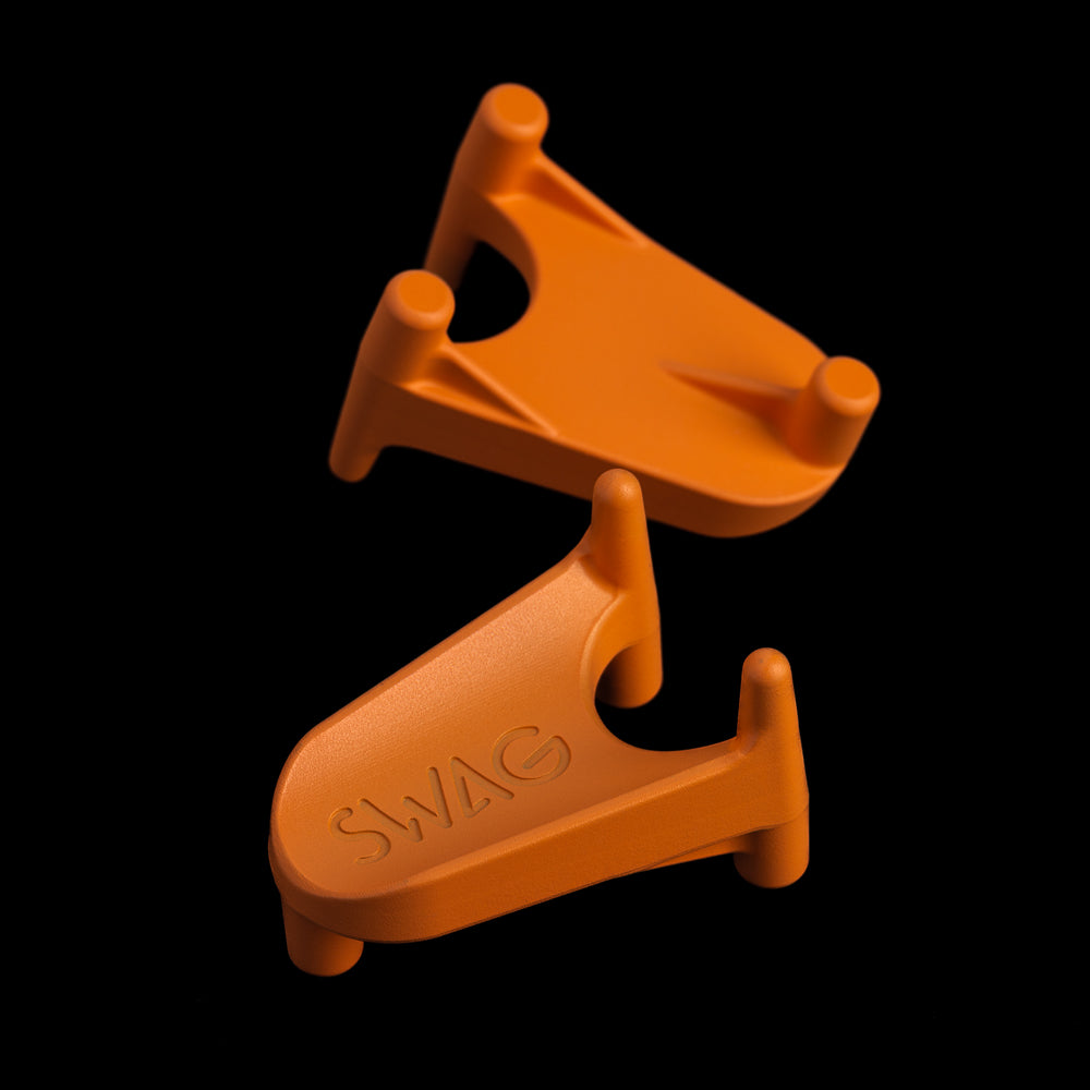 SWAG Golf orange mini kicking tee golf ball marker accessory made of stainless steel.