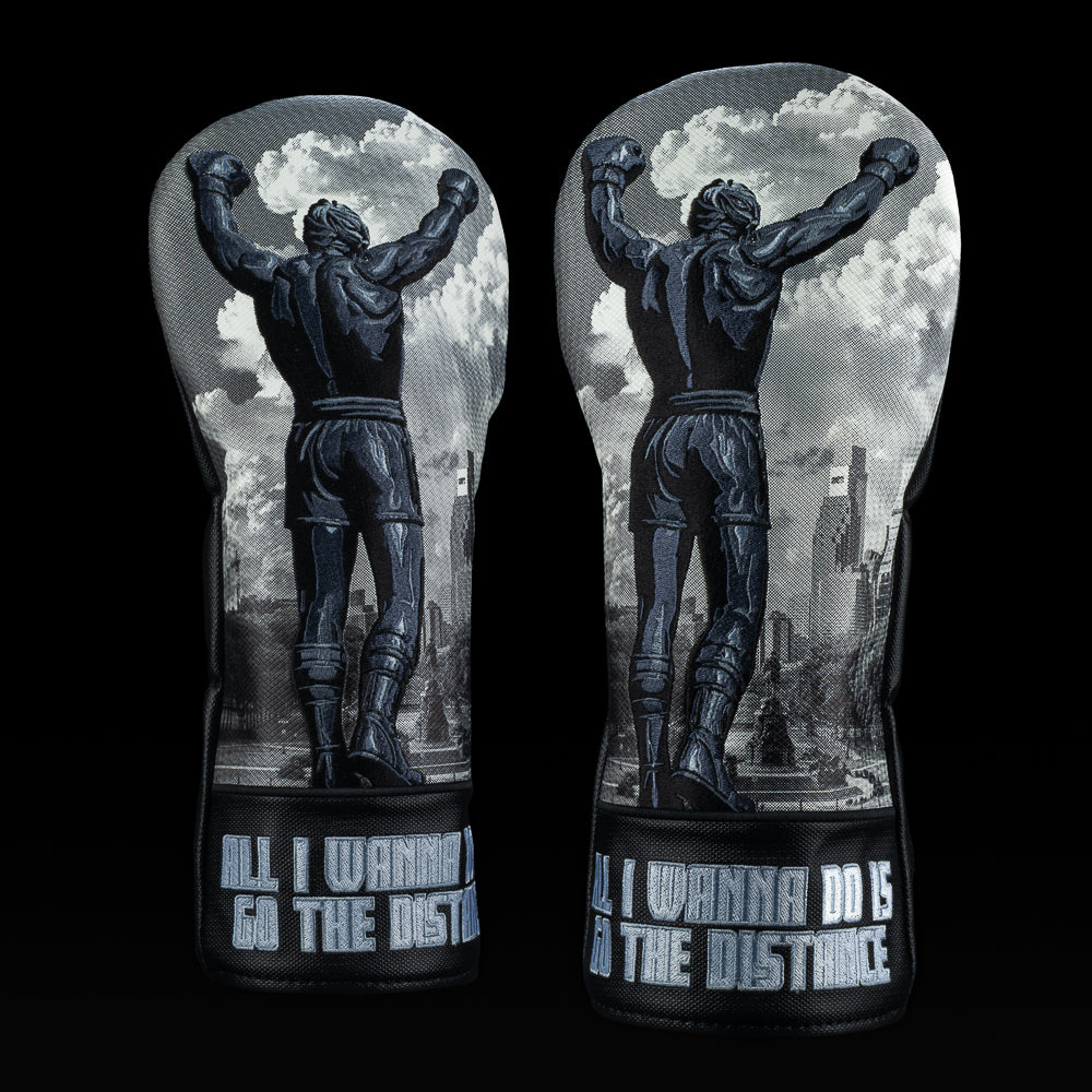 Black and gray SWAG Golf Let Freedom Ring driver cover featuring victory pose artwork, cityscape background, and “All I Wanna Do Is Go The Distance” embroidery.