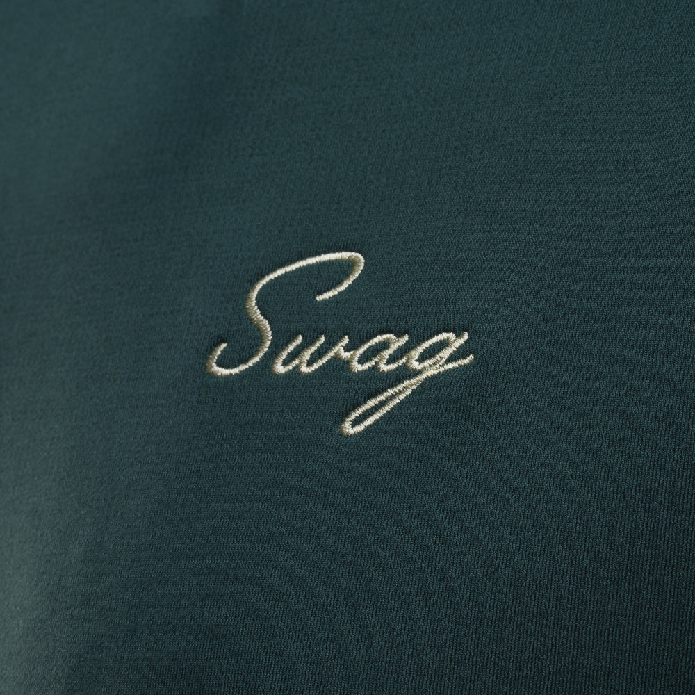 Person wearing a nordic green long sleeve performance golf hoodie with 'Swag' logo.