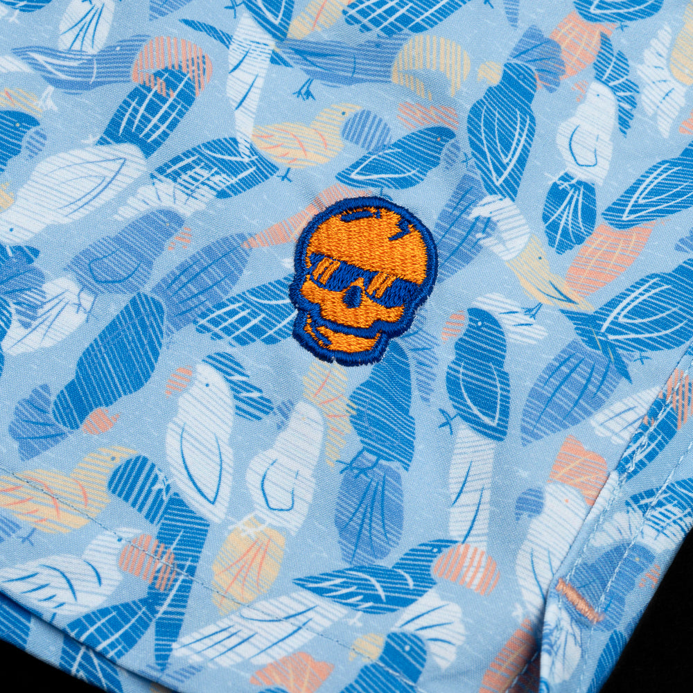 Flip the Bird Orange Skull with blue parrots pattern swim trunks.