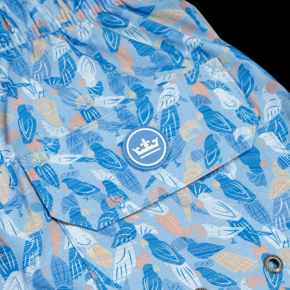 Flip the Bird Orange Skull with blue parrots pattern swim trunks.