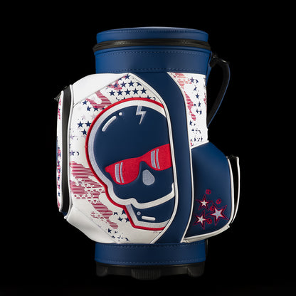 Left-side view of the USA Skull Stars & Stripes Den Caddy Cooler showing the oversized navy skull, red embroidered sunglasses, silver accents, star pattern and navy accessory pocket.