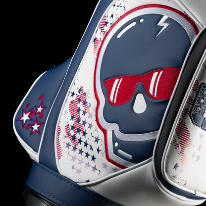 Close-up of the USA Skull Stars & Stripes Den Caddy Cooler featuring the navy skull, bright red sunglasses, silver embroidered outline and distressed patriotic star pattern.