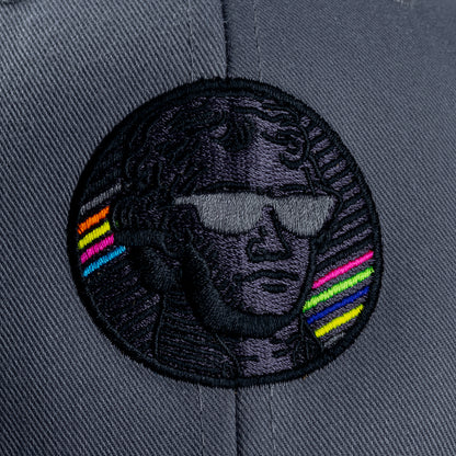Close-up of embroidered Jefferson portrait patch on gray Blackout Bills hat with black thread and neon rainbow stripe accents.