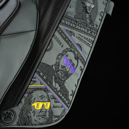 Gray SWAG Golf x Vessel golf stand bag with colorful dollar bill themed designs on a black background.