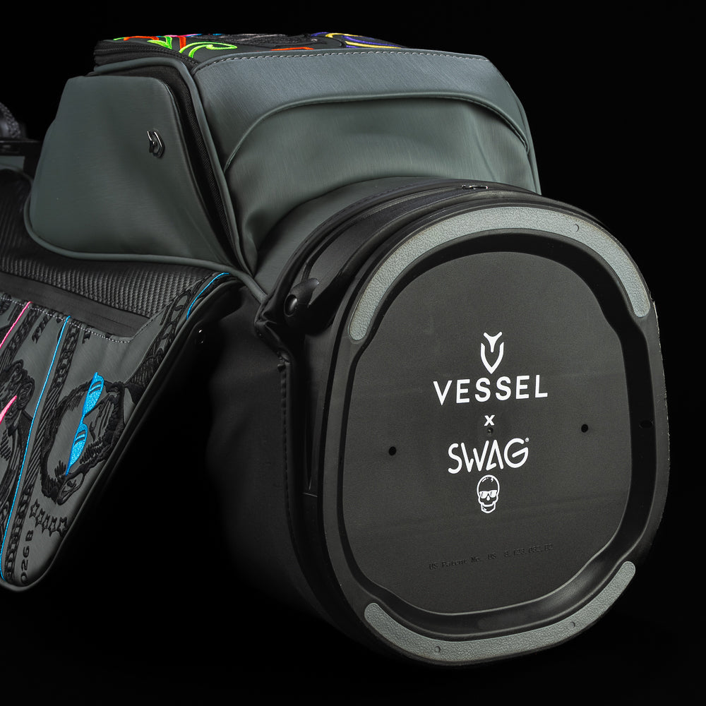 Gray SWAG Golf x Vessel golf stand bag with colorful dollar bill themed designs on a black background.