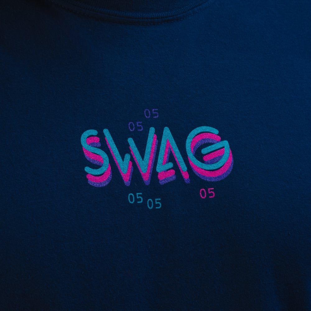 Close-up of neon pink and teal SWAG chest logo with repeated 05 graphic detail on navy Gigantic Lincoln long sleeve shirt.