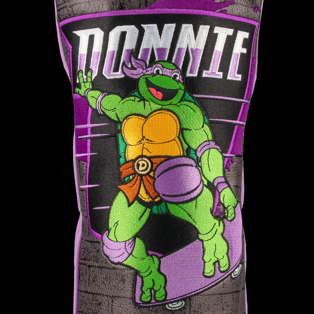 TMNT Donnie driver cover featuring bold purple and brick details. A classic Teenage Mutant Ninja Turtles Turtle Power style.