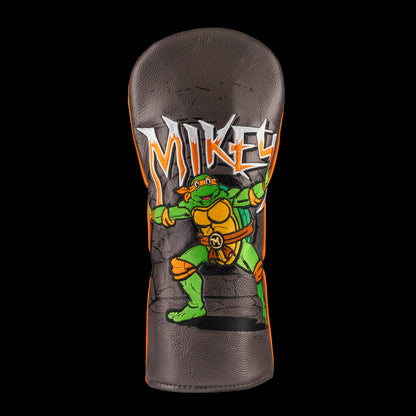 Orange TMNT Mikey driver cover with cartoon design.