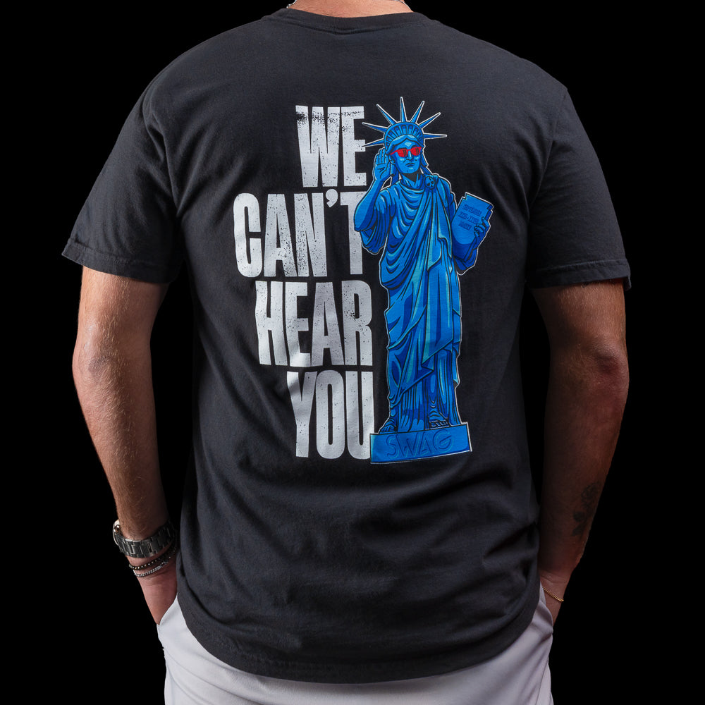 Black t-shirt with blue Statue of Liberty graphic and text 'WE CAN'T HEAR YOU' on the back.
