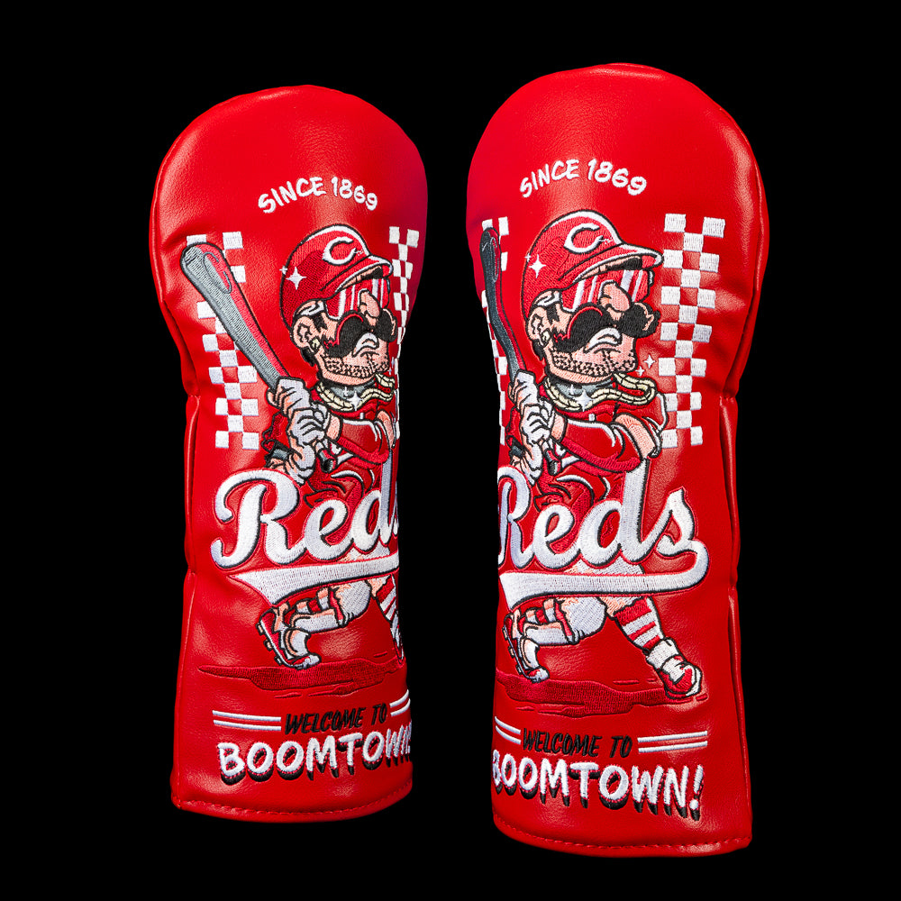 SWAG Golf Cincinnati Reds fairway cover featuring a mustached batter in a vintage Reds uniform and sunglasses, checkerboard racing graphics, "Since 1869" lettering, oversized Reds script, and "Welcome to Boomtown!" embroidered across the bottom on a bold red design.