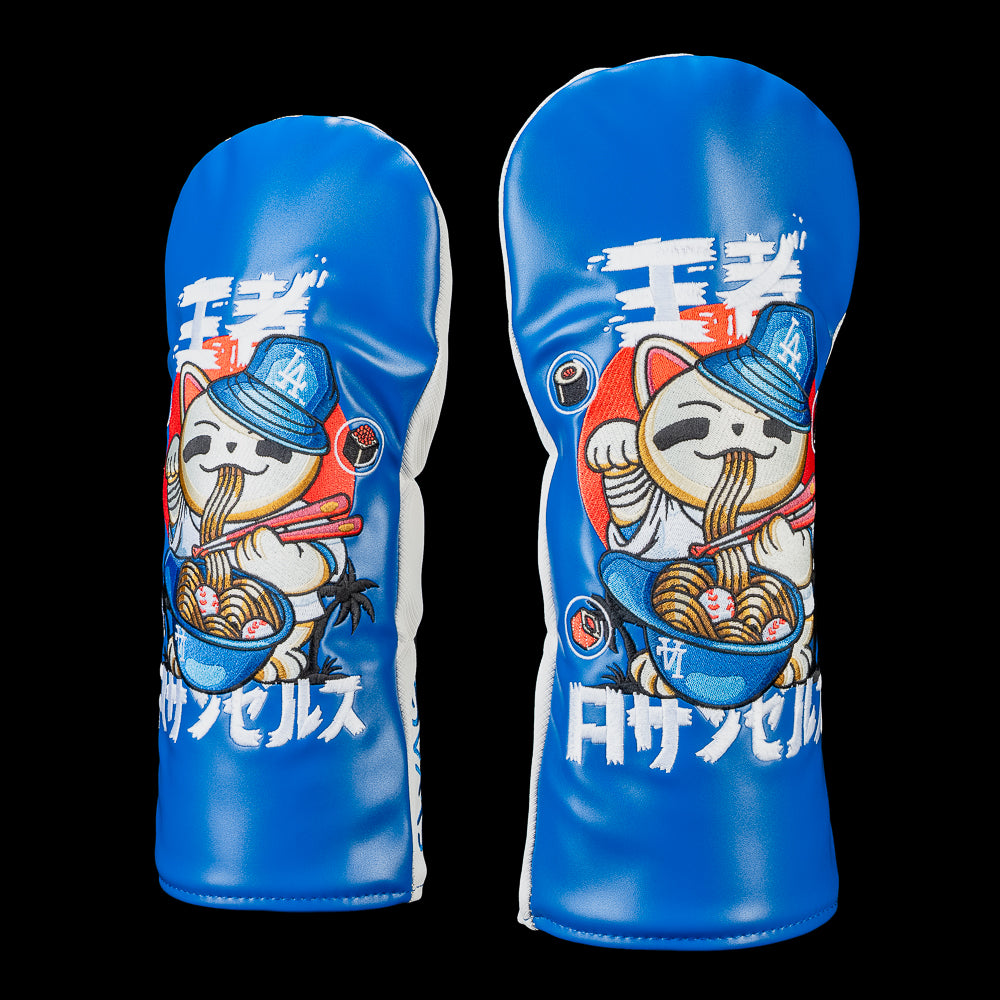 Officially licensed Los Angeles Dodgers driver cover shown from two front angles, highlighting an embroidered lucky cat in a Dodgers cap enjoying ramen with baseballs in the bowl, set against a Dodgers blue background with Japanese-inspired graphics and premium stitched detailing.