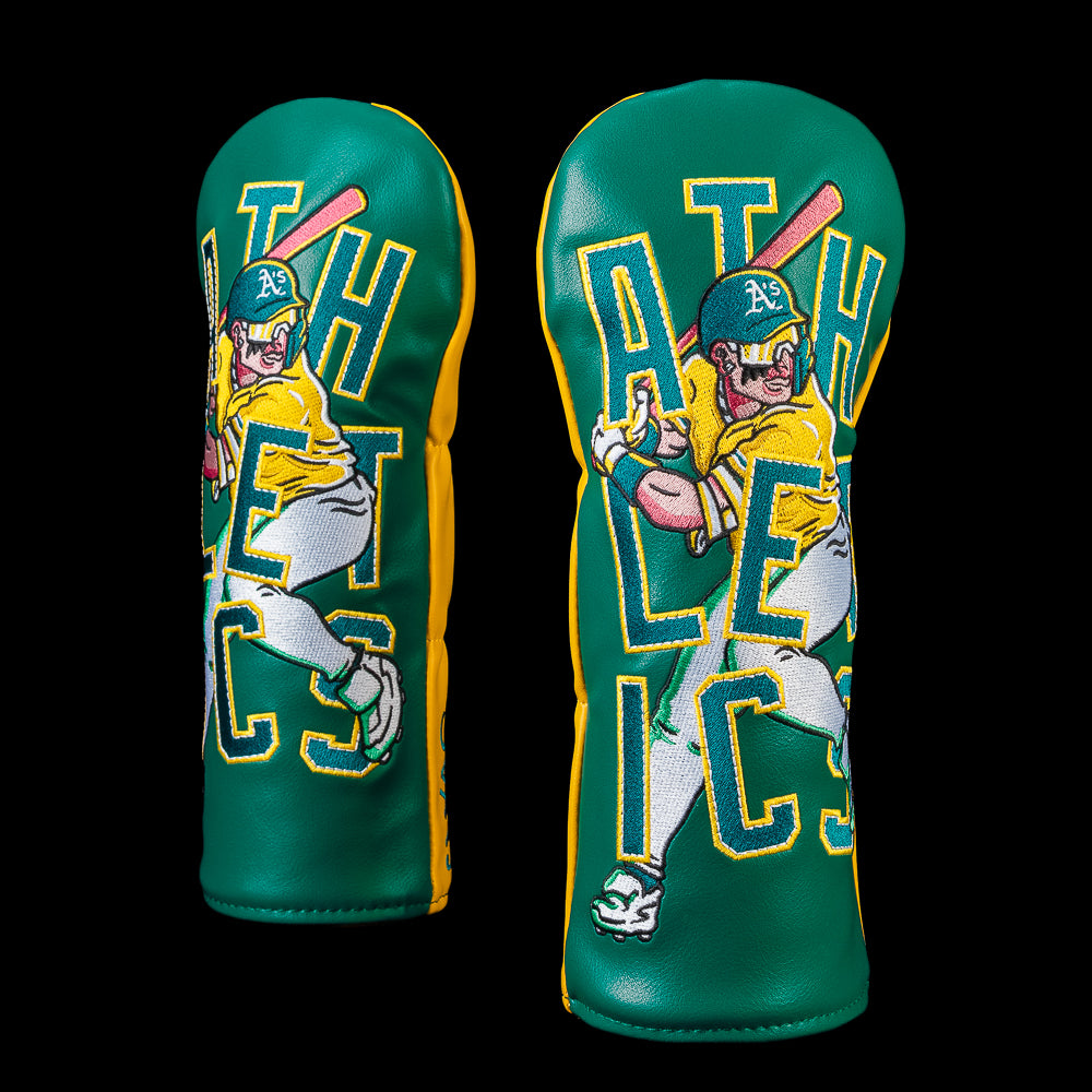 SWAG Golf Athletics fairway cover featuring a comic-style batter swinging in front of oversized ATHLETICS lettering with classic green and gold team colors and premium embroidery.