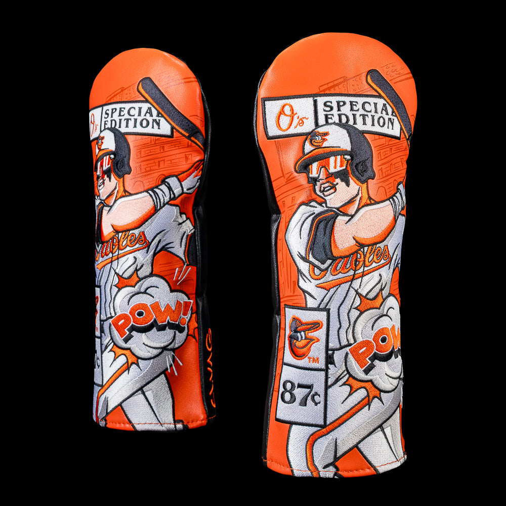 SWAG Golf Baltimore Orioles fairway cover featuring vibrant orange comic book artwork with an Orioles batter, "Special Edition" sign, vintage price tag, and POW! graphic.