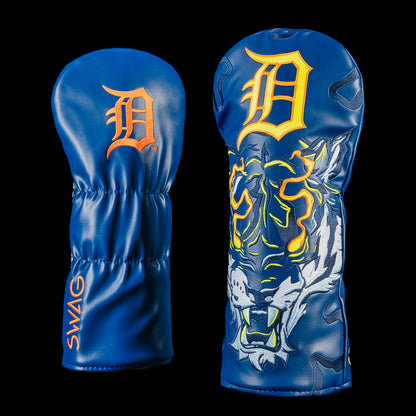 Detroit Tigers Night Prowl Driver Cover shown from the front and back. One side features a deep navy blue design with an embroidered "D" logo, the opposite side showcases a fierce white tiger with glowing orange accents. Orange SWAG branding along the side of the cover.