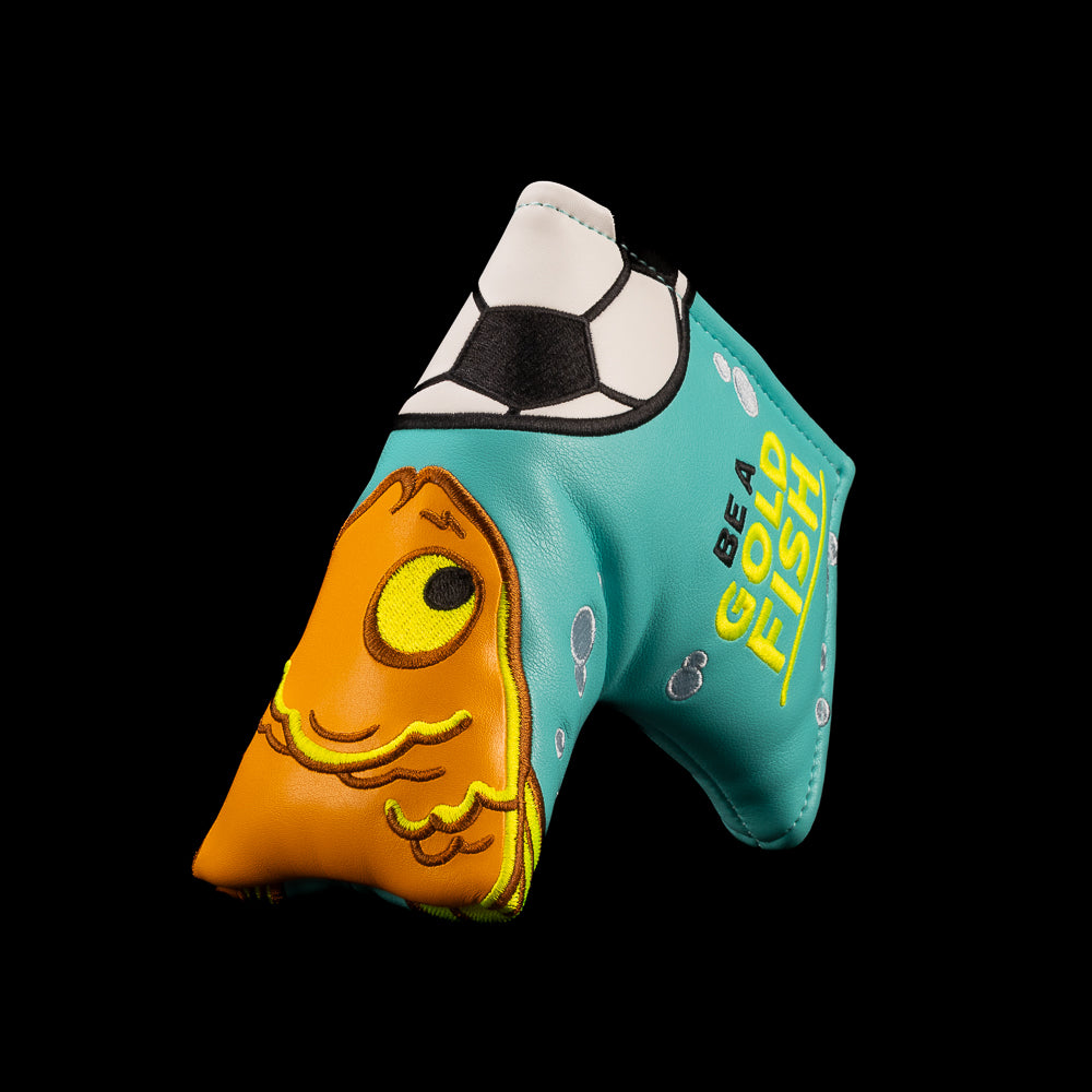 A turquoise and orange golf blade putter cover featuring a cartoon fish design and the text 'BE A GOLDFISH' on a solid black background. Officially licensed Ted Lasso design from Rewind Golf.