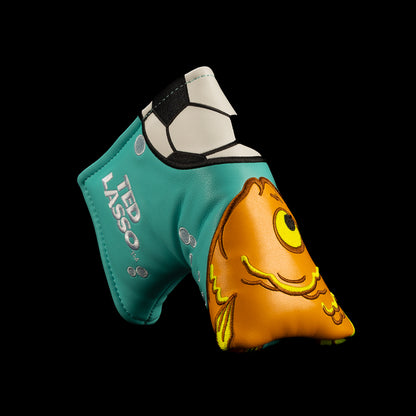 A turquoise and orange golf blade putter cover featuring a cartoon fish design and the text 'BE A GOLDFISH' on a solid black background. Officially licensed Ted Lasso design from Rewind Golf.