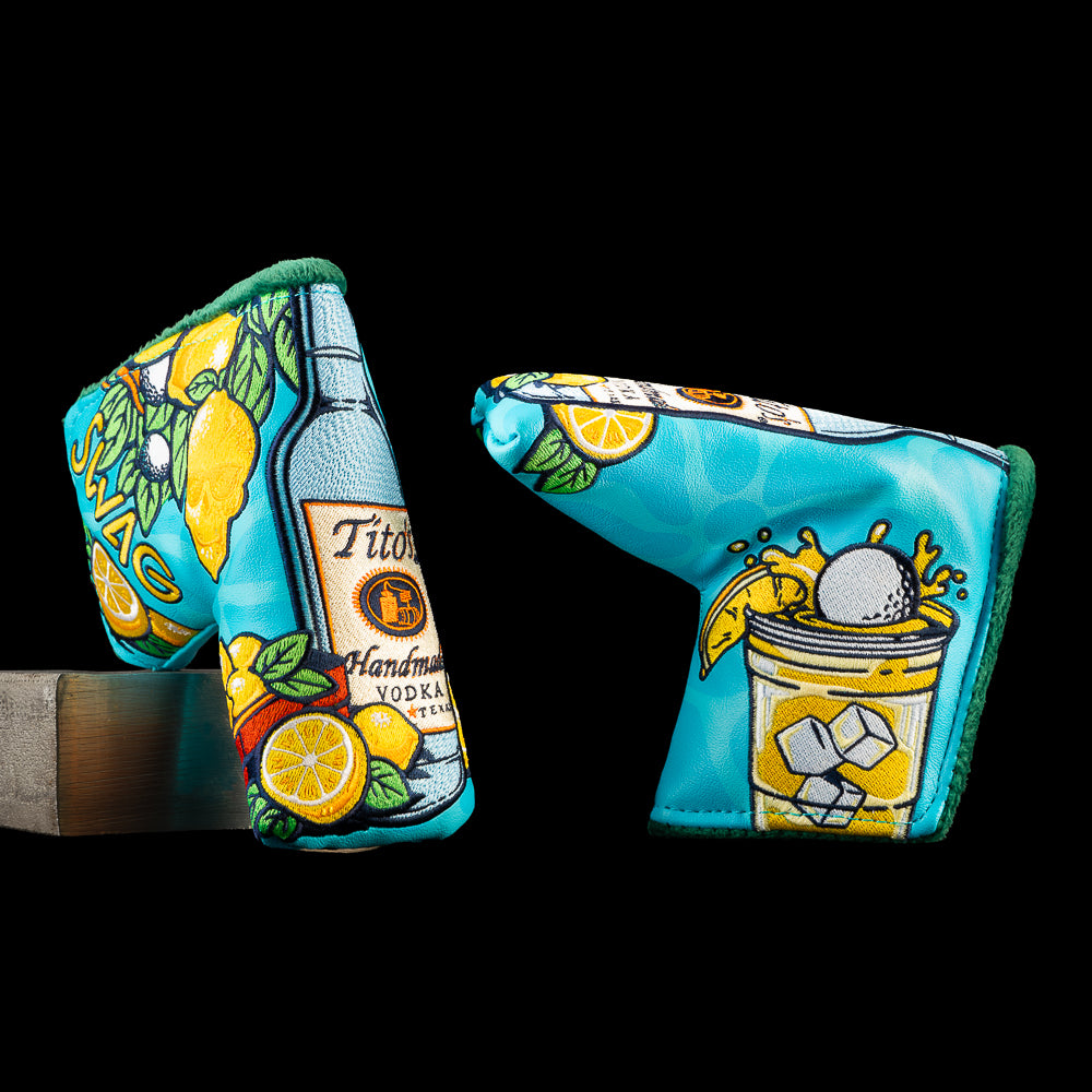 SWAG Golf Tito's & Lemonade blade putter cover featuring a turquoise design with a Tito's Vodka, lemons, citrus slices, leaves, a golf ball splashing into a cocktail, and embroidered ice cubes.