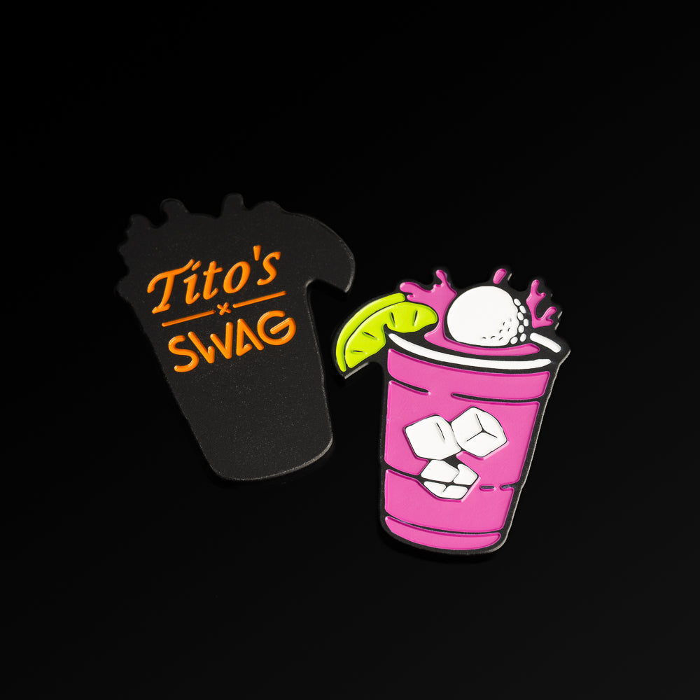 Tito's x SWAG ball marker featuring purple grape drink, Tito's graphics, lime slice, and splash design. With Tito's X SWAG logo on the flip.