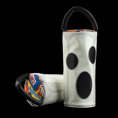 A pair of white glow-in-the-dark driver golf headcovers with black circular accents and black handles, displayed against a solid black background.