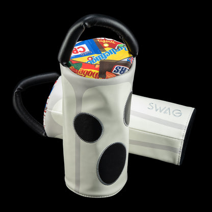 A pair of white glow-in-the-dark driver golf headcovers with black circular accents and black handles, displayed against a solid black background.