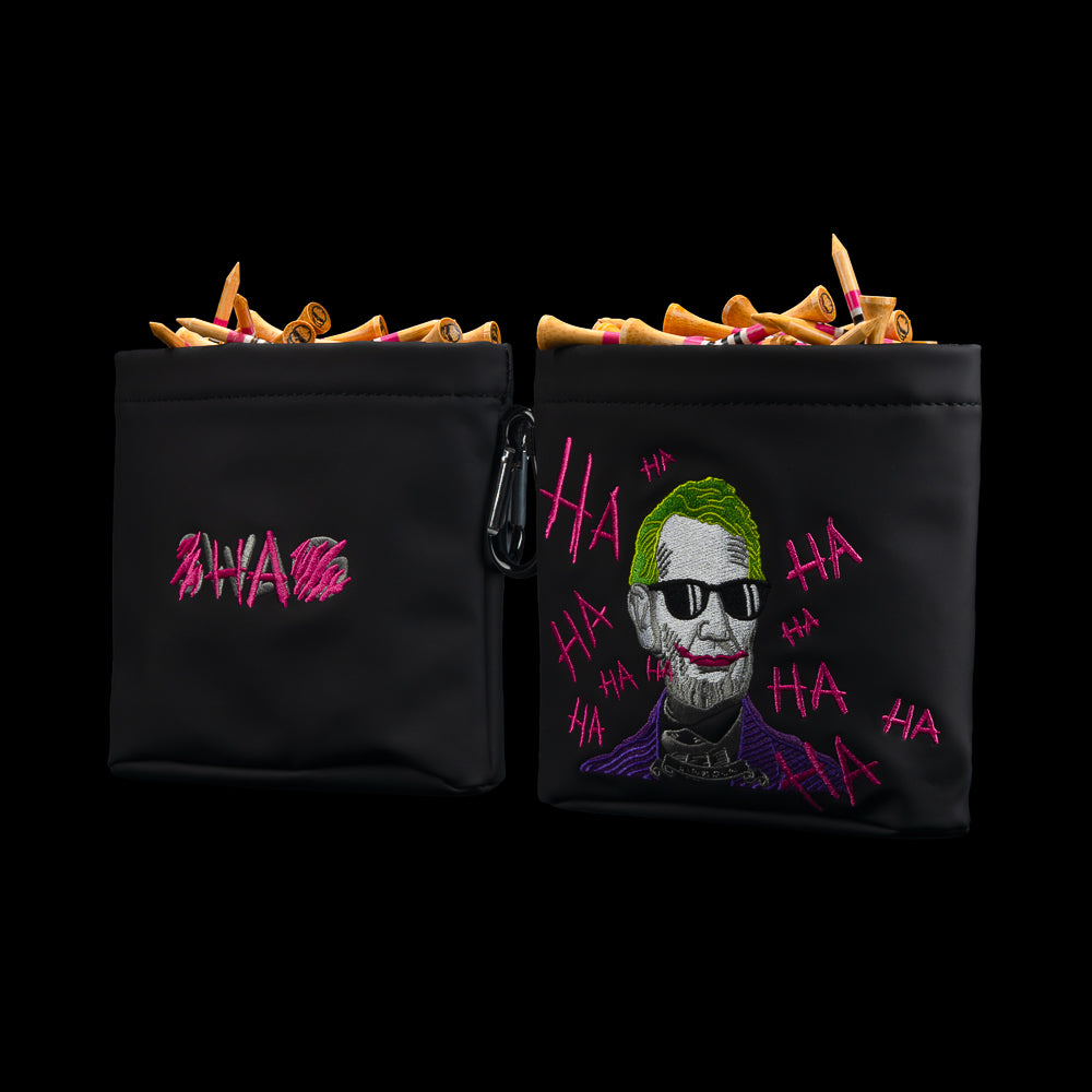 Front and back views of SWAG Golf black Defaced Lincoln tee pouch with portrait artwork, pink graffiti, and SWAG logo.