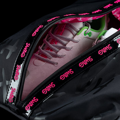Open SWAG Golf Defaced shoe bag showing golf shoes inside and pink SWAG lettering along the zipper.
