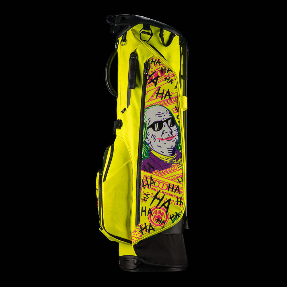 SWAG Golf x Vessel VLS Lux golf stand bag with neon yellow material and embroidered Defaced Franklin design on pink dollar bill themed panels. 