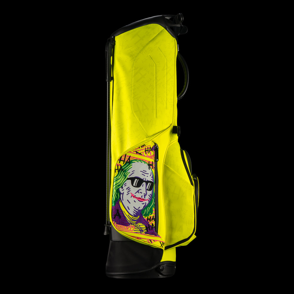 SWAG Golf x Vessel VLS Lux golf stand bag with neon yellow material and embroidered Defaced Franklin design on pink dollar bill themed panels. 