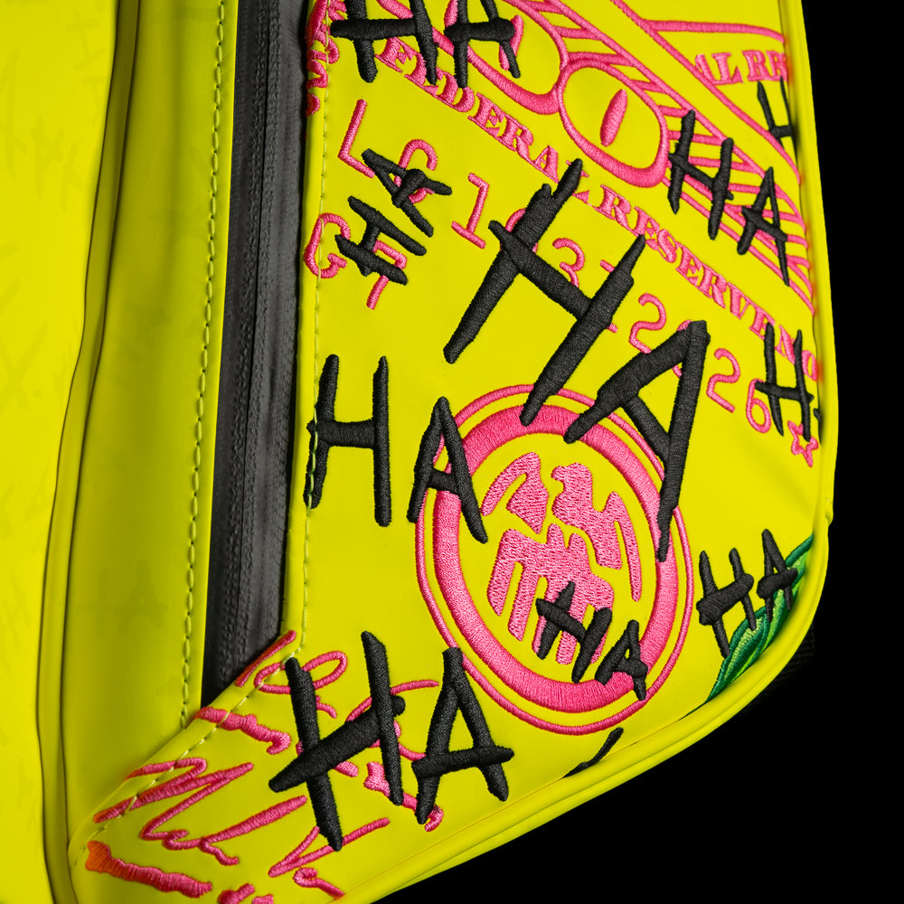 SWAG Golf x Vessel VLS Lux golf stand bag with neon yellow material and embroidered Defaced Franklin design on pink dollar bill themed panels. 