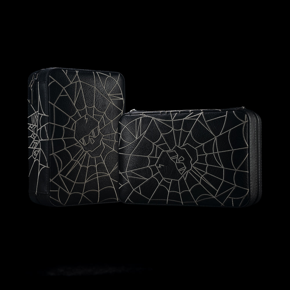 Black SWAG Golf Spider Web cigar humidor travel case shown from two exterior angles with gray web artwork and a central skull emblem.