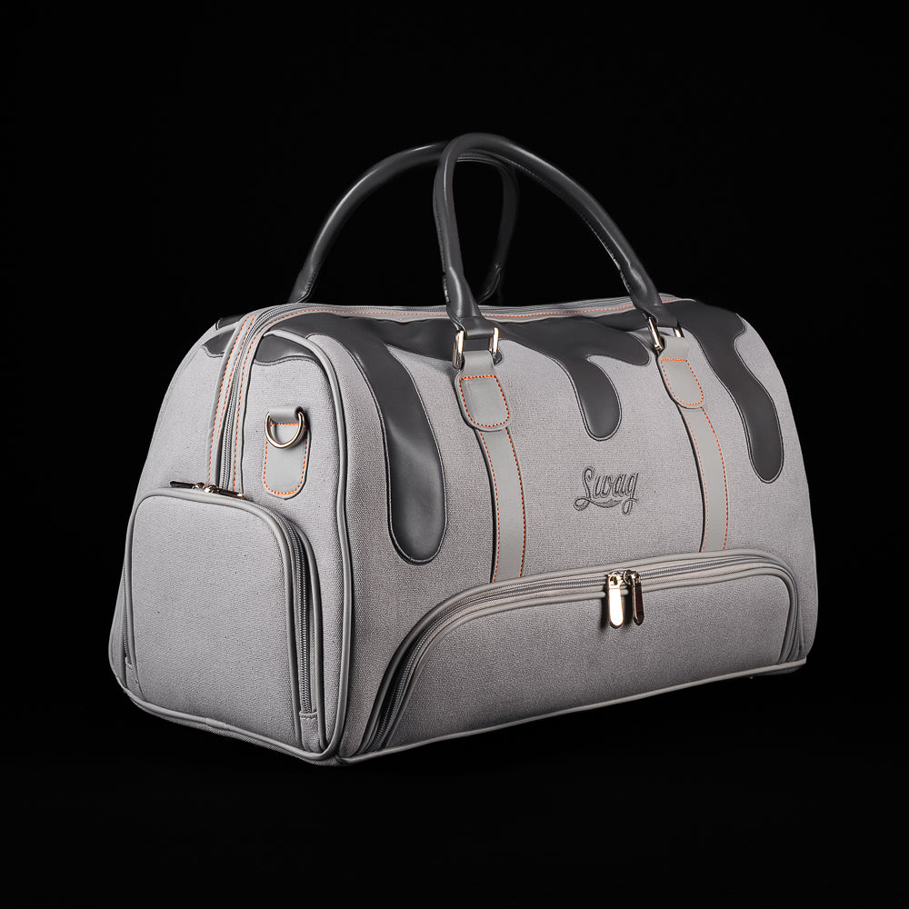 Angled view of SWAG Golf Dripping Duffle Bag featuring grey construction, black drip graphics, and multiple storage pockets.